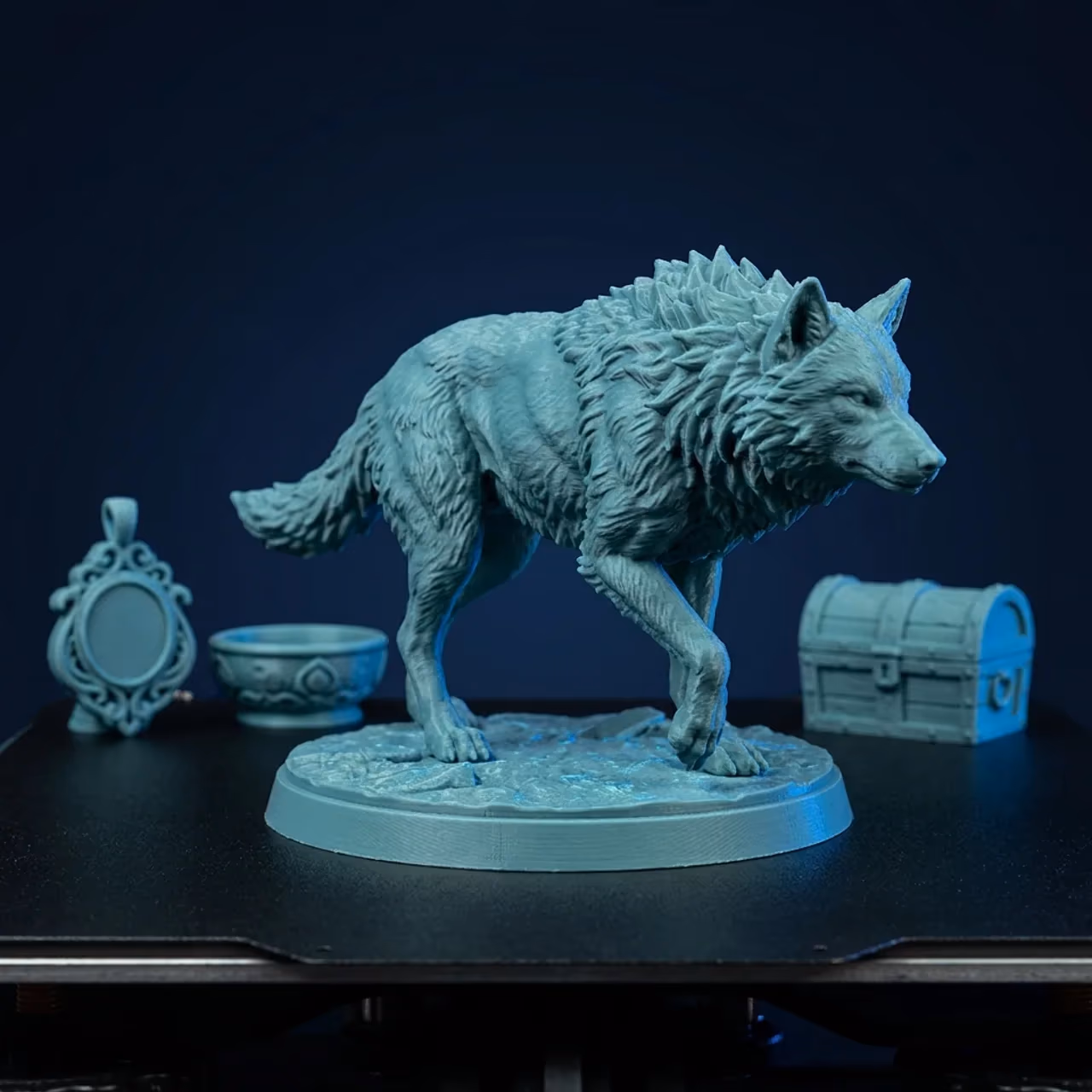 A detailed teal 3D printed wolf miniature on a round base on a build plate, with a smaller printed bowl and treasure chest behind it